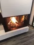 Hogar de leña ARGENTO 660 DC Basic — visión panorámica del fuego en chimenea de tres caras